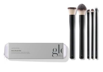 A collection of five high-performance, vegan makeup brushes displayed alongside their packaging which reads 'hero brush set'. The brushes are designed for various makeup applications including powder, concealer, foundation, eyeshadow, and eyeliner.